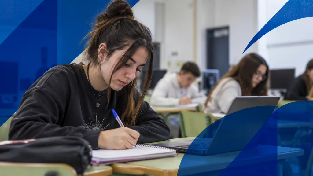 Estudiante de estilo urbano en un aula de Rumasa, trabajando con cuaderno y portátil en un entorno de Formación Profesional.